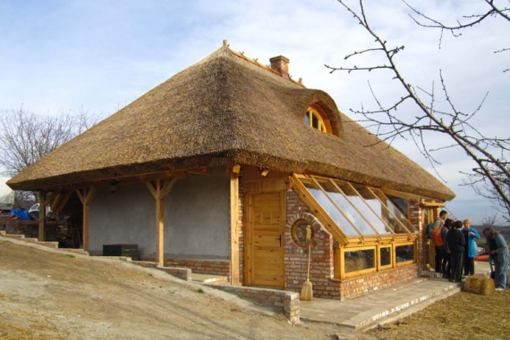 Дом из соломы с камышовой крышей и теплицей