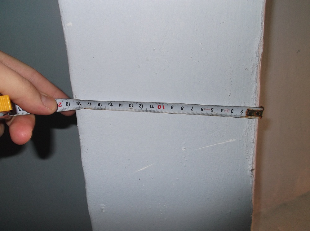 Измерение толщины стены рулеткой перед сносом