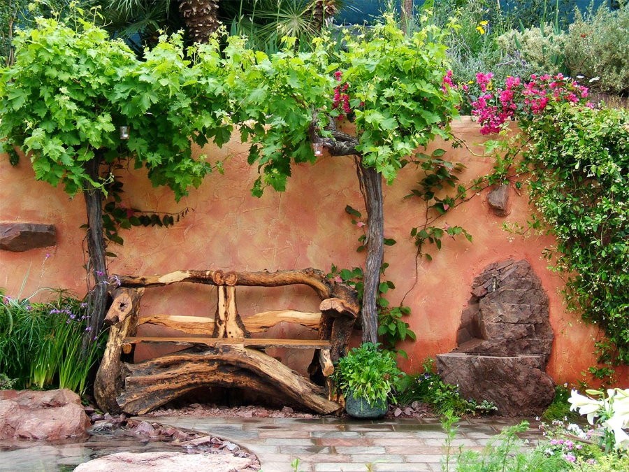 Самодельная скамейка из дерева возле стены сарая