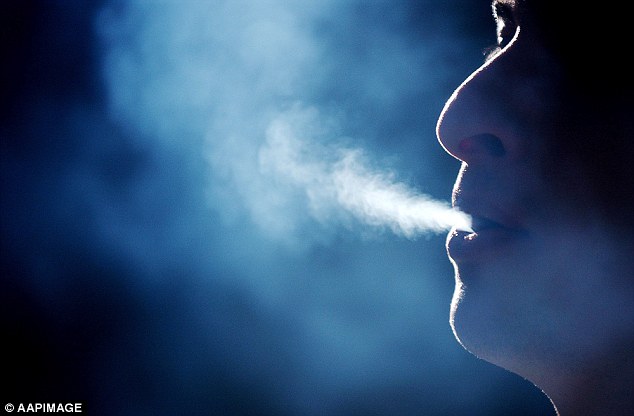 A person in the Brisbane CBD exhales smoke from a cigarette