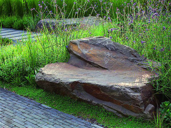 Из большой глыбы камня вручную вытесан вместительный диван со спинкой. Подобный арт-объект особенно гармонично смотрится в саду природного стиля.