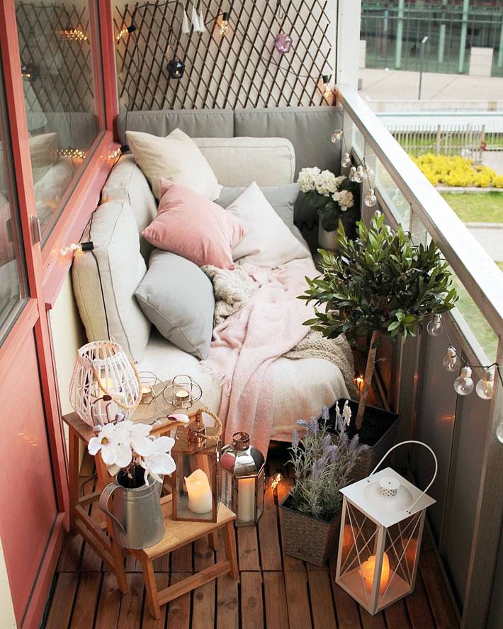 декоративные подушки, свечи и гирлянды на балконе