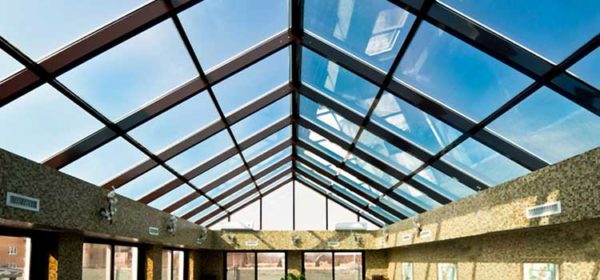Сплошная двускатная конструкция из стекла и металла — хорошее решение для обустройства бассейнов, зимних садов и теплиц