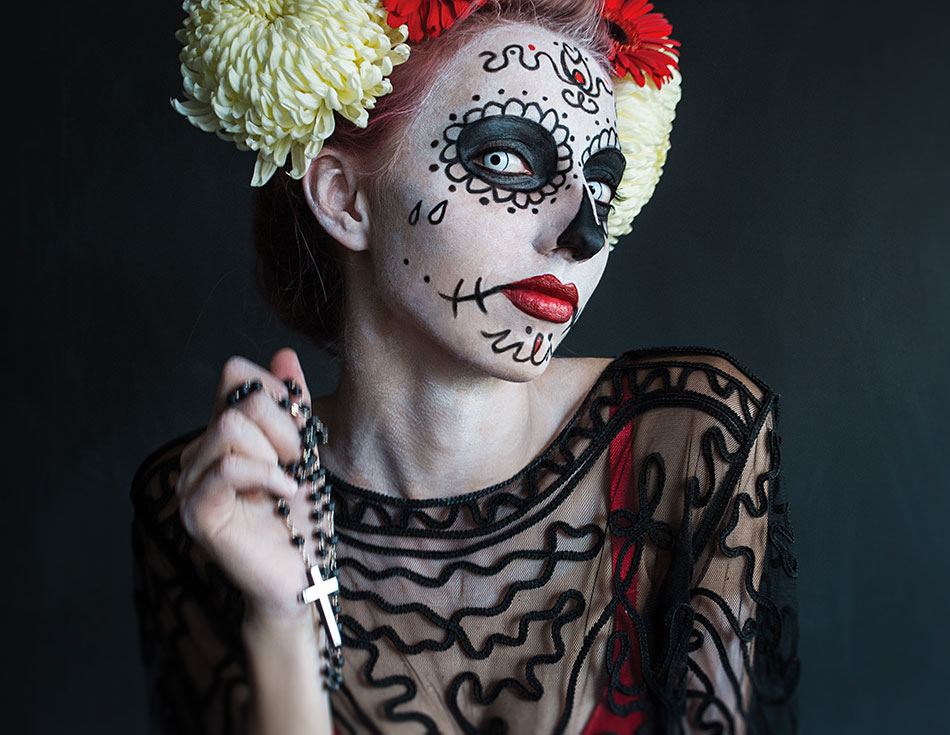 woman dressed in day of the dead costume with blue colored contact lenses